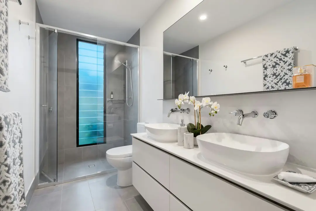 Bagno moderno con doccia in vetro e mobile bianco